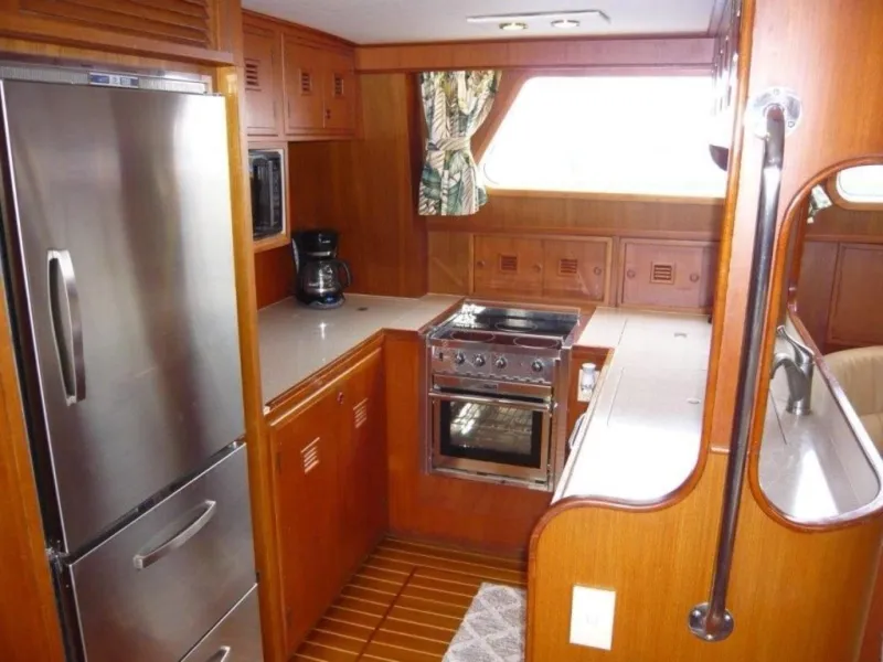Slide: The Image of 1990 Cheoy Lee Sloop kitchen with wood cabinetry, stainless steel appliances, and compact design. - 38
