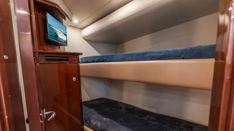 Slide: The Image of 2008 Sea Ray Sundancer cabin with bunk beds and a small TV. - 14