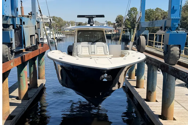 Slide: The Image of 2020 Scout 380 LXF boat suspended in a marina lift, ready for launch. - 10