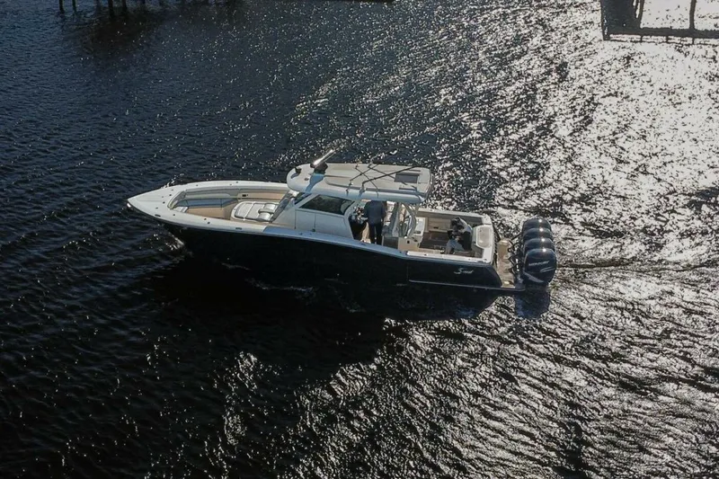 Slide: The Image of 2020 Scout 380 LXF boat cruising on sunlit water. - 2