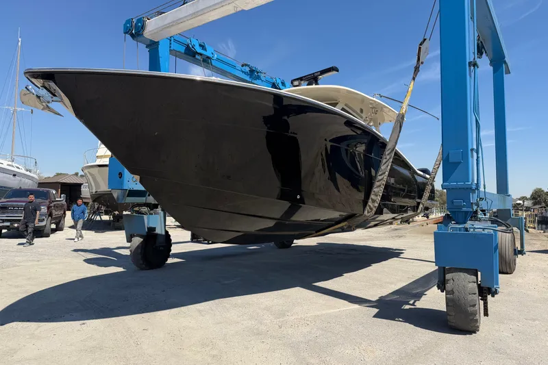 Slide: The Image of 2020 Scout 380 LXF boat being lifted by a blue crane at a marina. - 6