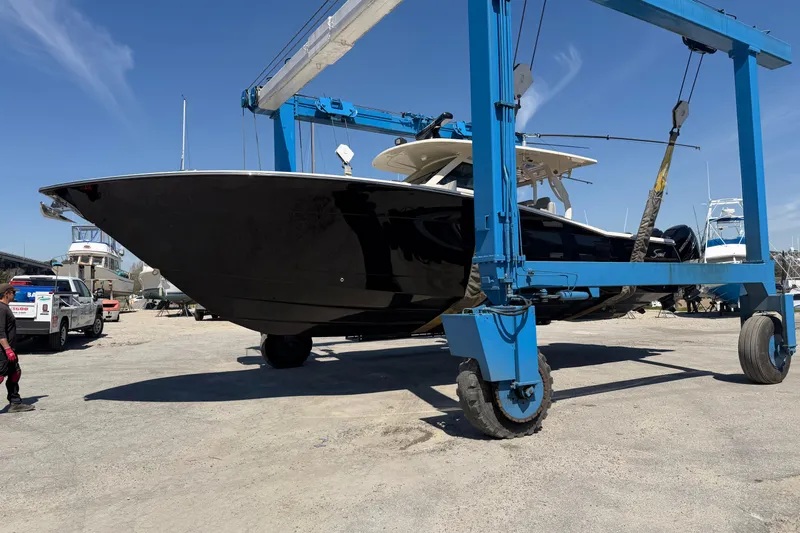 Slide: The Image of 2020 Scout 380 LXF boat on a lift at a marina under clear blue skies. - 8