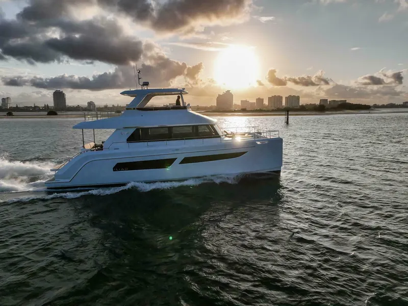 Slide: The Image of Luxury yacht ILIAD 53F cruising at sunset, 2026 model, with city skyline in background. - 20