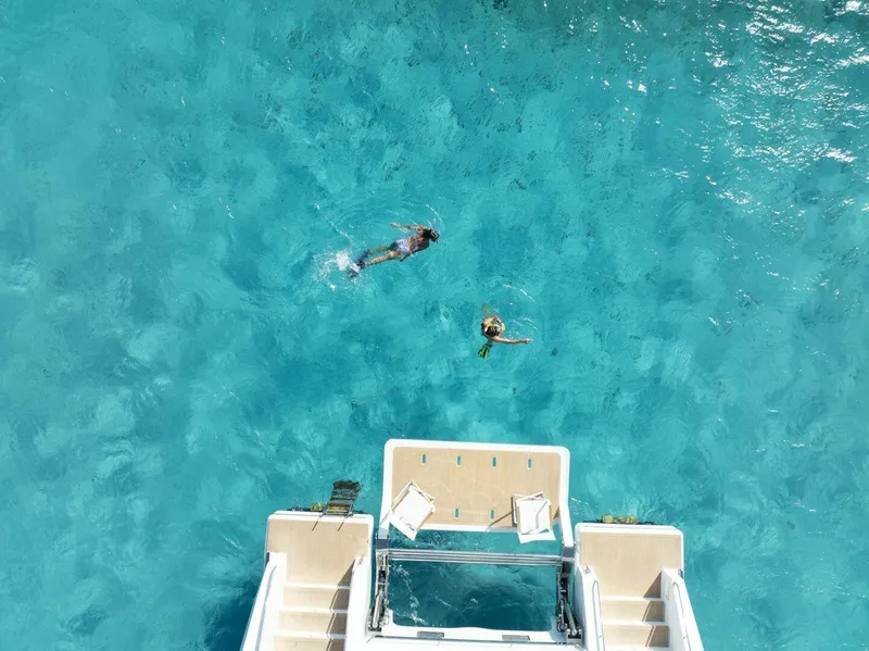 Slide: The Image of Aerial view of swimmers near ILIAD 53F yacht in clear blue water, 2026. - 3