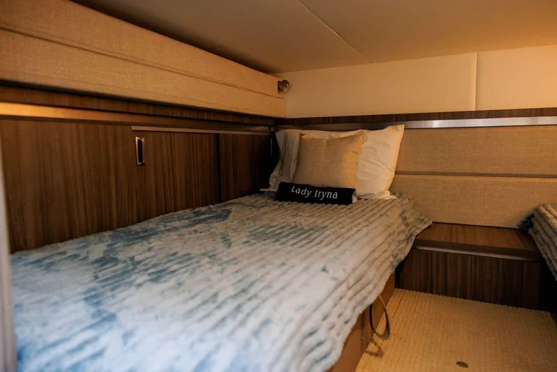 Slide: The Image of 2022 Sea Ray Sundancer 320 Outboard cabin interior with cozy bedding and wood accents. - 15