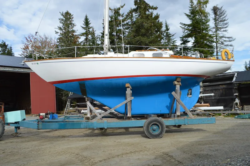 The Image of 1967 Alberg 35 sailboat on trailer, white hull, blue keel, outdoor setting. - 1