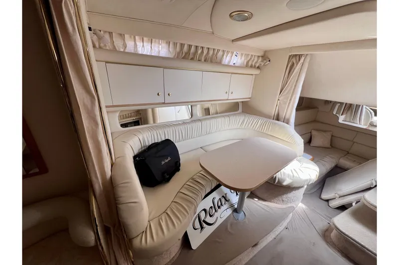 Slide: The Image of Interior of 2000 Sea Ray 340 Sundancer with cream leather seating and dining table. - 12