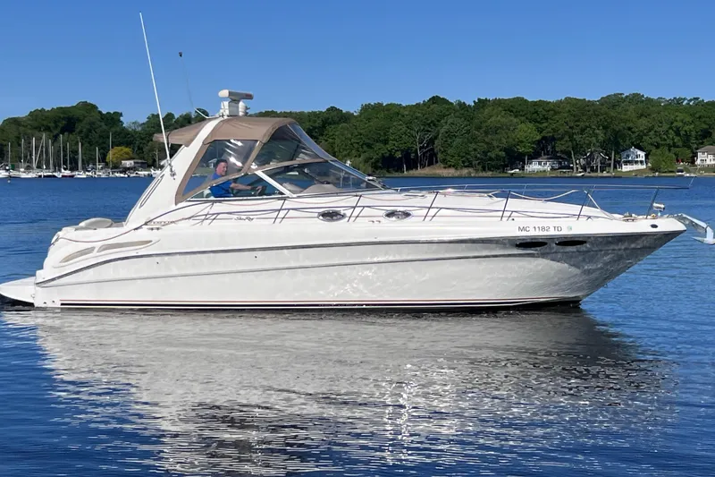 Slide: The Image of 2000 Sea Ray 340 Sundancer yacht cruising on a calm lake under clear blue skies. - 5