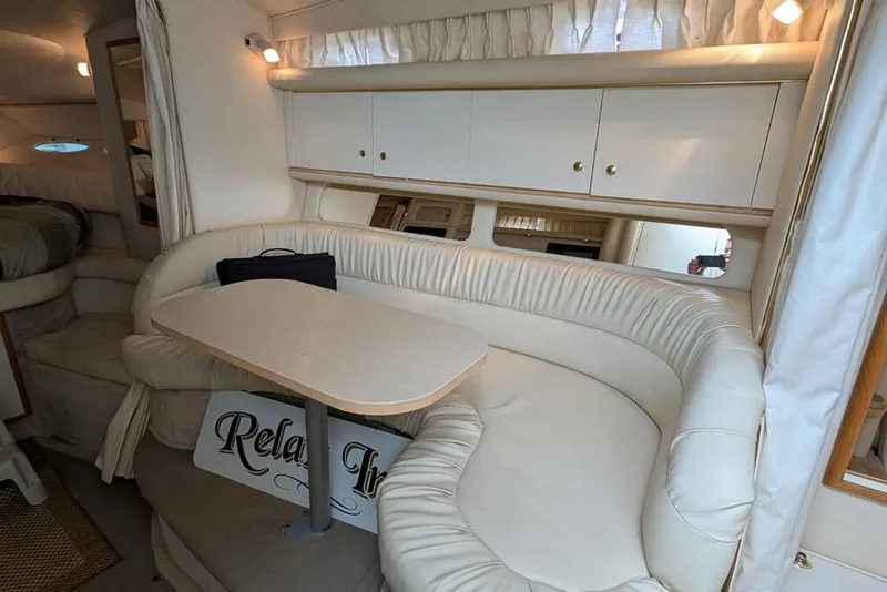 Slide: The Image of Interior of 2000 Sea Ray 340 Sundancer with cream leather seating and table. - 9