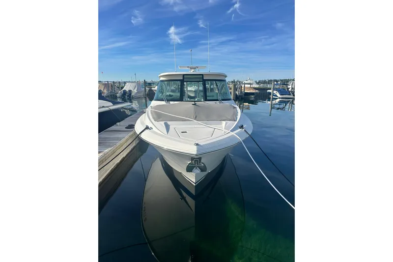 Slide: The Image of 2021 Tiara Yachts 34 LX docked at marina under clear blue sky. - 1