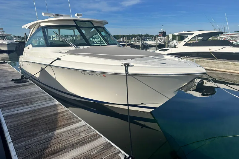 Slide: The Image of 2021 Tiara Yachts 34 LX docked at marina under clear blue sky. - 2