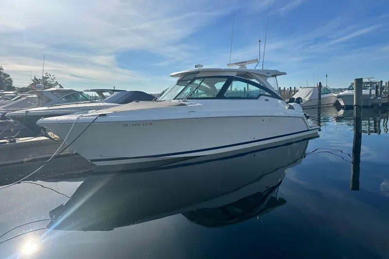 Slide: The Image of 2021 Tiara Yachts 34 LX docked in a marina under a clear blue sky. - 5
