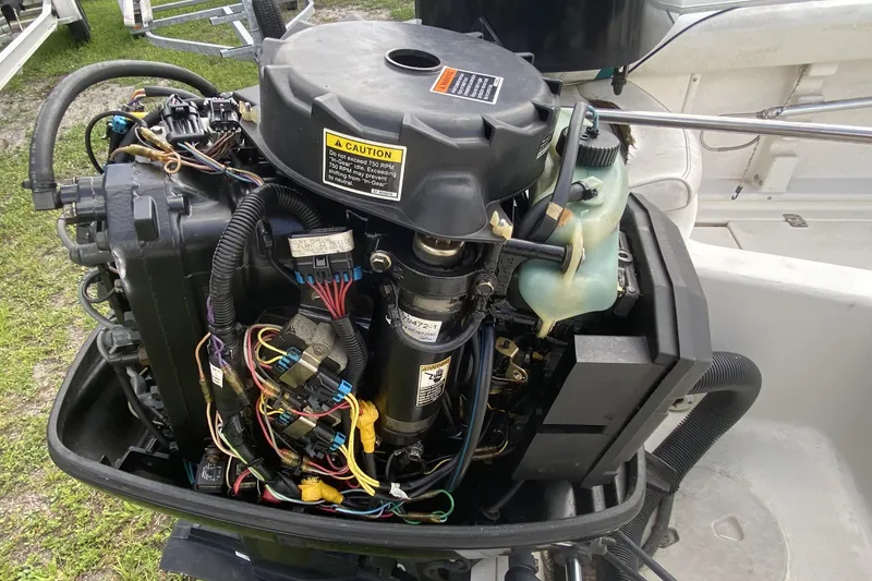 Slide: The Image of 2001 Aquasport 215 Osprey Sport boat engine with visible wiring and components. - 13