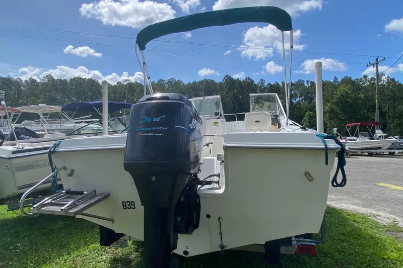 Slide: The Image of 2001 Aquasport 215 Osprey Sport boat with outboard motor, parked outdoors. - 5
