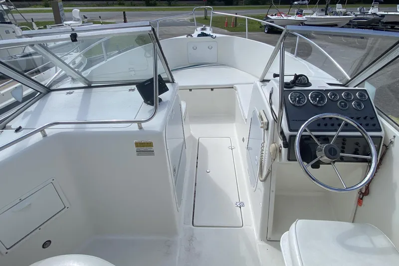 Slide: The Image of 2001 Aquasport 215 Osprey Sport boat interior with steering wheel and dashboard controls. - 6