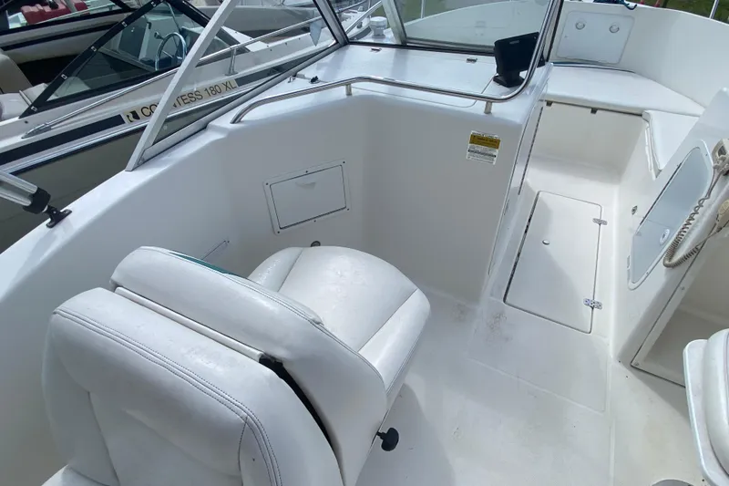 Slide: The Image of 2001 Aquasport 215 Osprey Sport boat interior with white seating and storage compartments. - 8