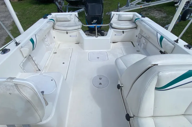 Slide: The Image of 2001 Aquasport 215 Osprey Sport boat interior with white seating and spacious deck. - 9