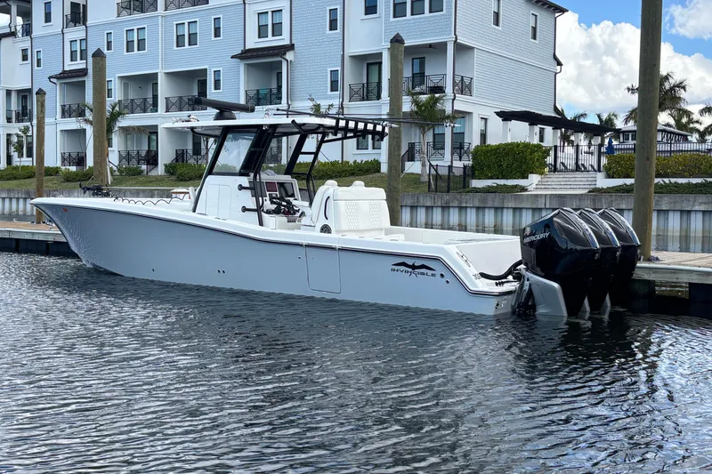 Slide: The Image of 2024 Invincible 36 Open Fisherman boat docked near waterfront homes. - 14