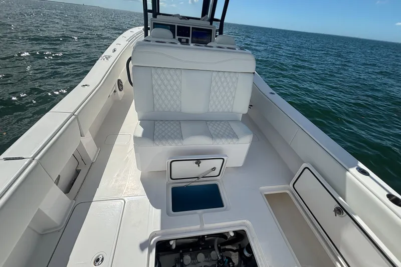 Slide: The Image of 2024 Invincible 36 Open Fisherman boat interior with white seating, ocean backdrop. - 20