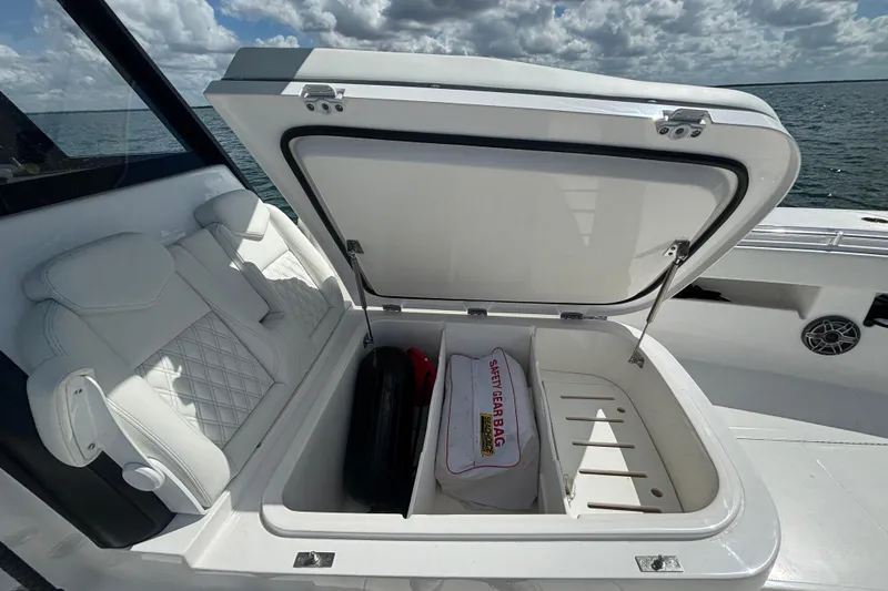 Slide: The Image of Open storage compartment on 2024 Invincible 36 Open Fisherman boat, featuring safety gear bag. - 46