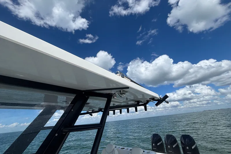 Slide: The Image of 2024 Invincible 36 Open Fisherman boat on water under blue sky with clouds. - 49