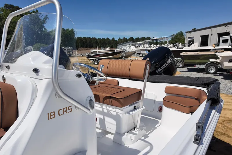 Slide: The Image of 2026 ALK2 Powerboats 18 CRS with brown seating and Suzuki engine in a boatyard. - 9