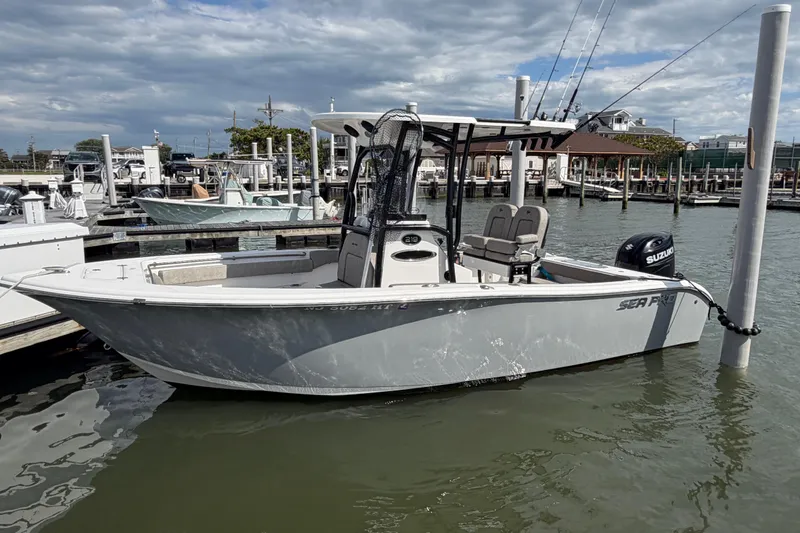 The Image of 2022 Sea Pro 219 Deep V CC boat docked at marina under cloudy sky. - 0