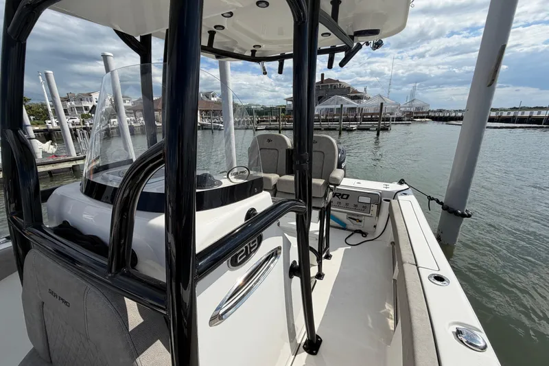 Slide: The Image of 2022 Sea Pro 219 Deep V CC boat docked at marina, showcasing interior and helm. - 12