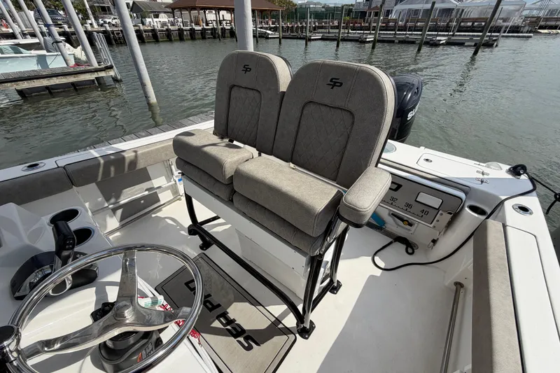 Slide: The Image of 2022 Sea Pro 219 Deep V CC boat interior with helm and seating at dock. - 13
