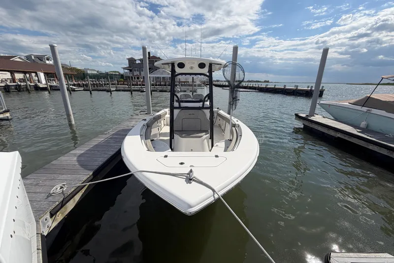 Slide: The Image of 2022 Sea Pro 219 Deep V CC boat docked at a marina under a partly cloudy sky. - 2