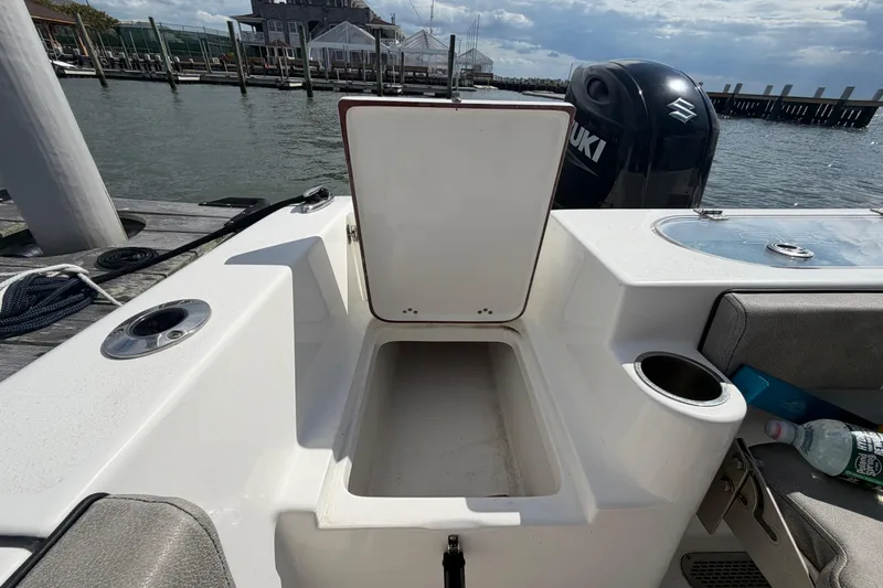 Slide: The Image of 2022 Sea Pro 219 Deep V CC boat with open storage compartment and Suzuki engine. - 28