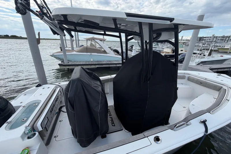 Slide: The Image of 2022 Sea Pro 219 Deep V CC boat docked at marina, featuring covered seating and console. - 5