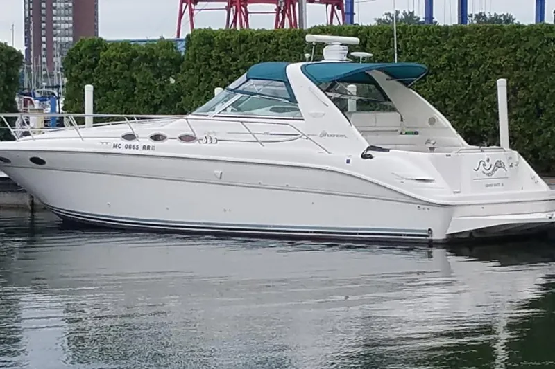 The Image of 1996 Sea Ray Sundancer 370 yacht docked in a marina, featuring a sleek white design. - 0