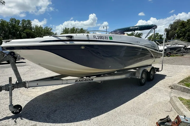 Slide: The Image of 2019 Hurricane Sundeck Sport 218 OB boat on Karavan trailer, parked outdoors. - 1