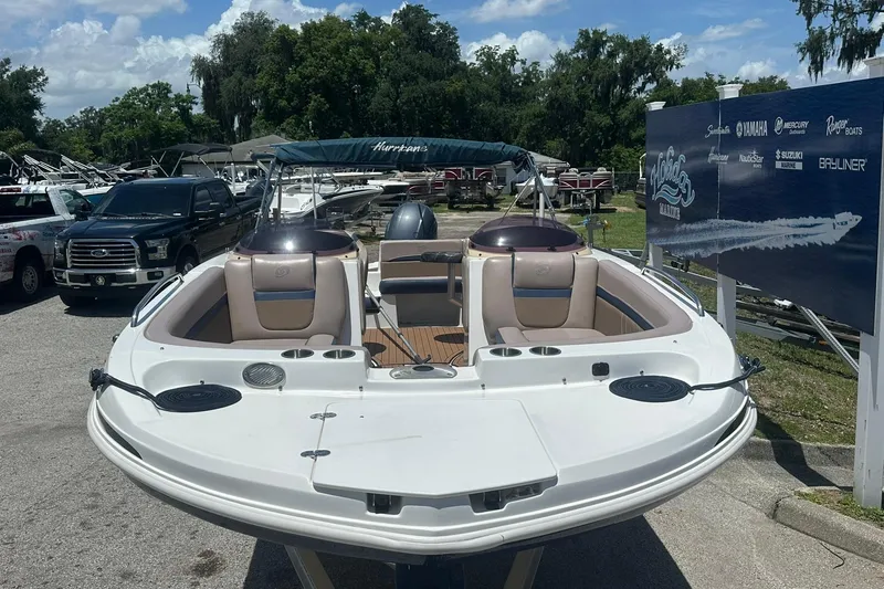 Slide: The Image of 2019 Hurricane Sundeck Sport 218 OB boat displayed outdoors with seating and canopy. - 2