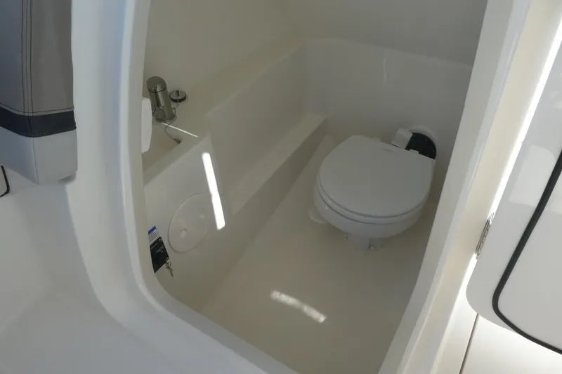 Slide: The Image of Interior of 2026 Boston Whaler 240 Vantage boat featuring a compact marine toilet. - 10