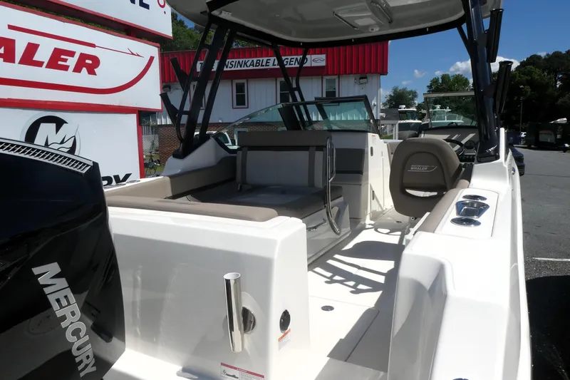 Slide: The Image of 2026 Boston Whaler 240 Vantage boat interior with Mercury engine, showcasing seating and controls. - 2