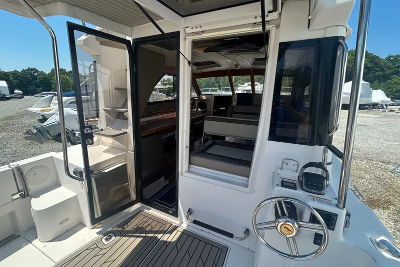 Slide: The Image of 2022 Cutwater C-30 CB boat interior with open door, showcasing seating and helm. - 6
