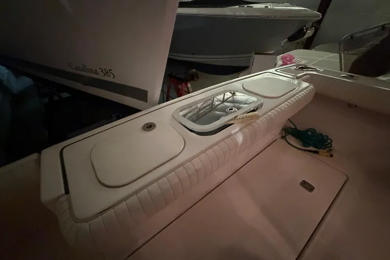 Slide: The Image of 2004 Tiara Yachts 3200 Open cockpit with storage compartments and Catalina 385 in background. - 13