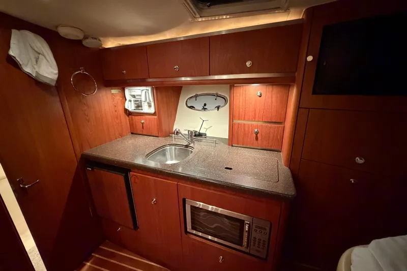 Slide: The Image of Luxurious 2004 Tiara Yachts 3200 Open galley with wood cabinetry and modern appliances. - 25