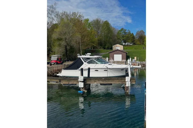 The Image of 2004 Tiara Yachts 3200 Open docked at a serene marina with lush greenery. - 0
