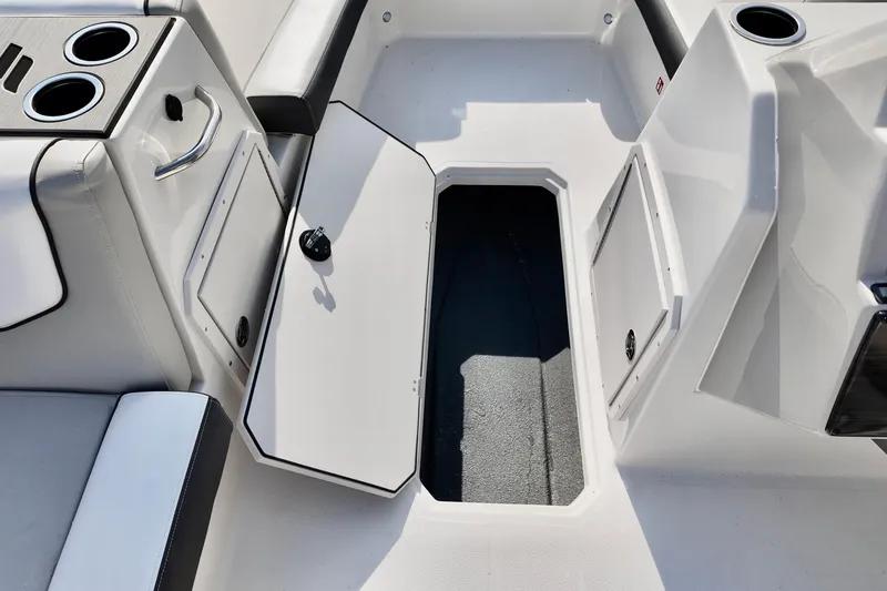 Slide: The Image of 2026 Starcraft SVX 211 OB boat interior with open storage compartment and cup holders. - 12
