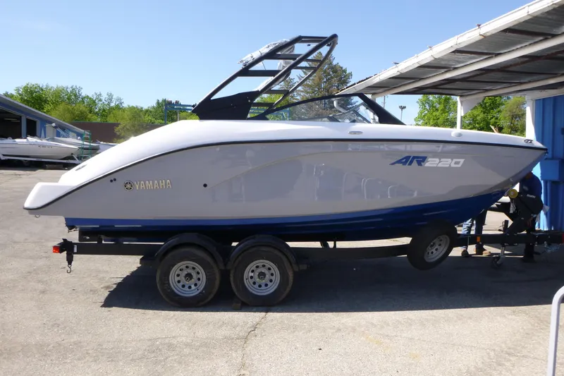 The Image of 2026 Yamaha Boats AR220 on trailer, parked outdoors under clear sky. - 1