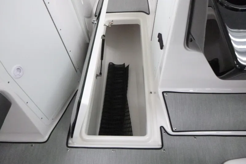 Slide: The Image of 2026 Yamaha Boats AR220 storage compartment with open hatch and black mat inside. - 10