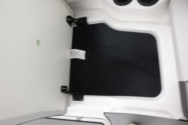 Slide: The Image of Interior view of 2026 Yamaha Boats AR220, featuring a black mat and white paneling. - 8