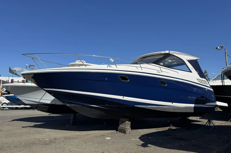 Slide: The Image of 2016 Regal 35 Sport Coupe boat displayed on dry land under clear blue sky. - 1