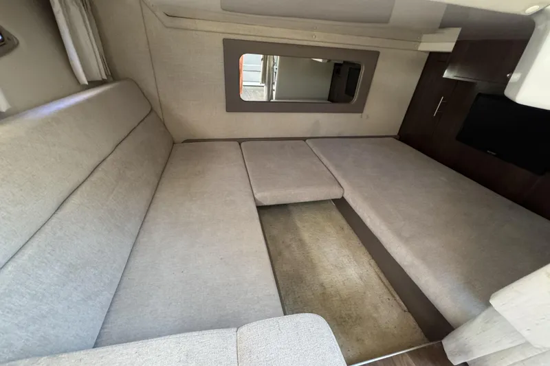 Slide: The Image of Interior of a 2016 Regal 35 Sport Coupe with beige seating and a wall mirror. - 17