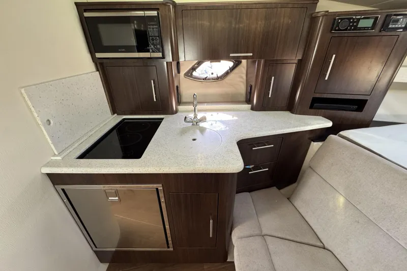 Slide: The Image of Compact kitchen area in a 2016 Regal 35 Sport Coupe with modern appliances. - 19