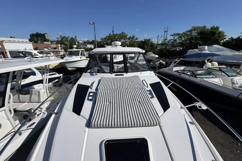 Slide: The Image of 2016 Regal 35 Sport Coupe boat docked among other vessels under a clear blue sky. - 22