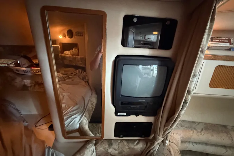 Slide: The Image of Interior of 1994 Sea Ray Sundancer 330 with TV, mirror, and cozy cabin space. - 27